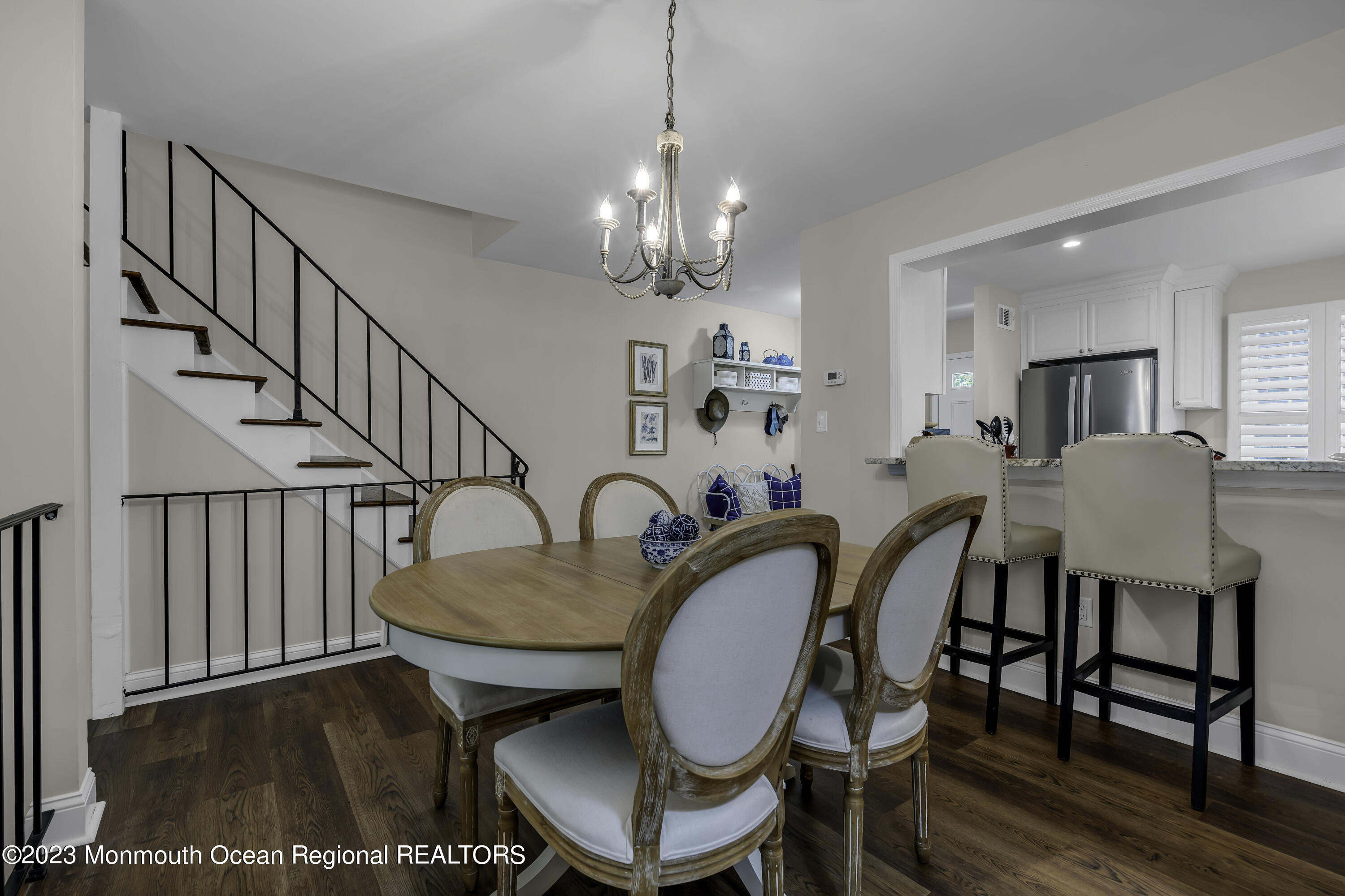 a dining room with wooden floor a chandelier a wooden table and chairs