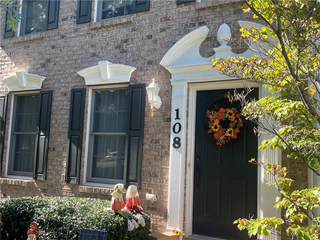 a front view of a house with a tree