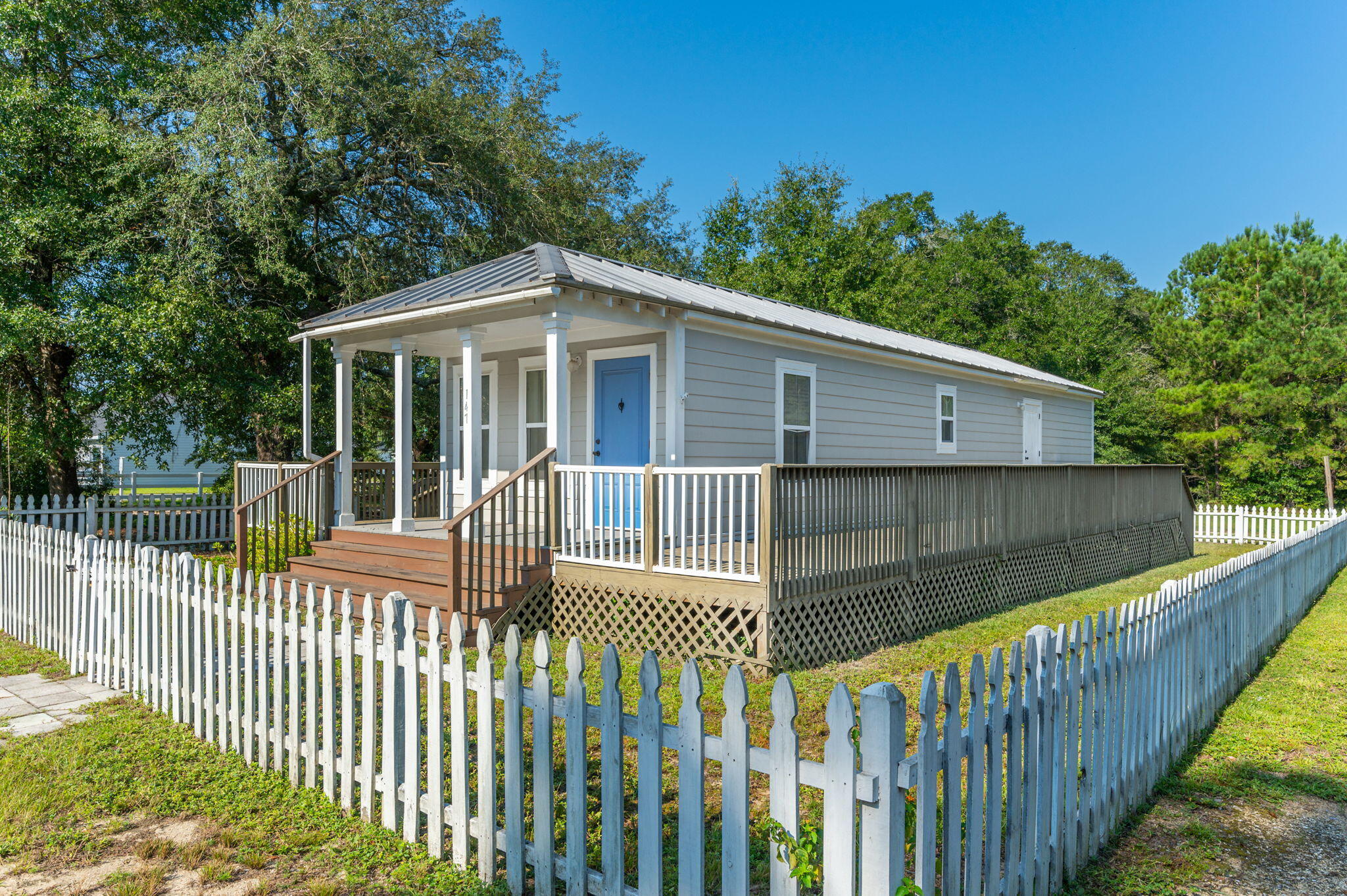 a view of a house with a small yard and wooden fence