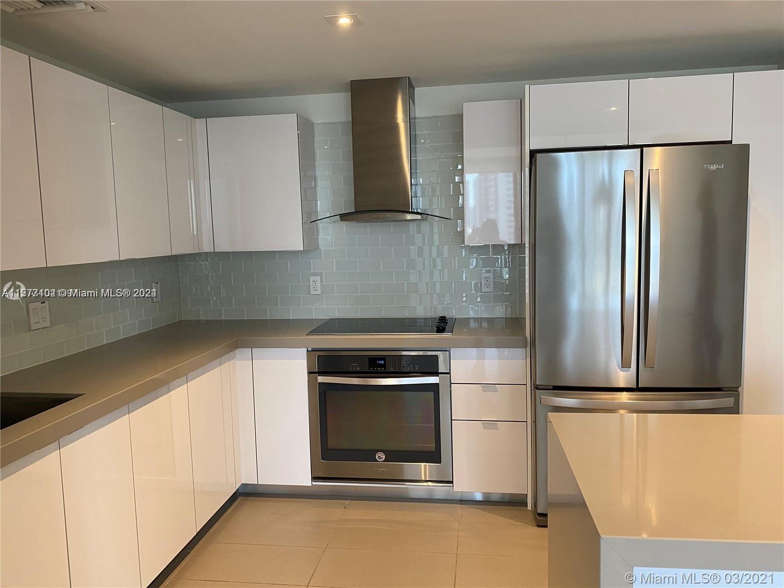 a kitchen with a refrigerator and a stove top oven