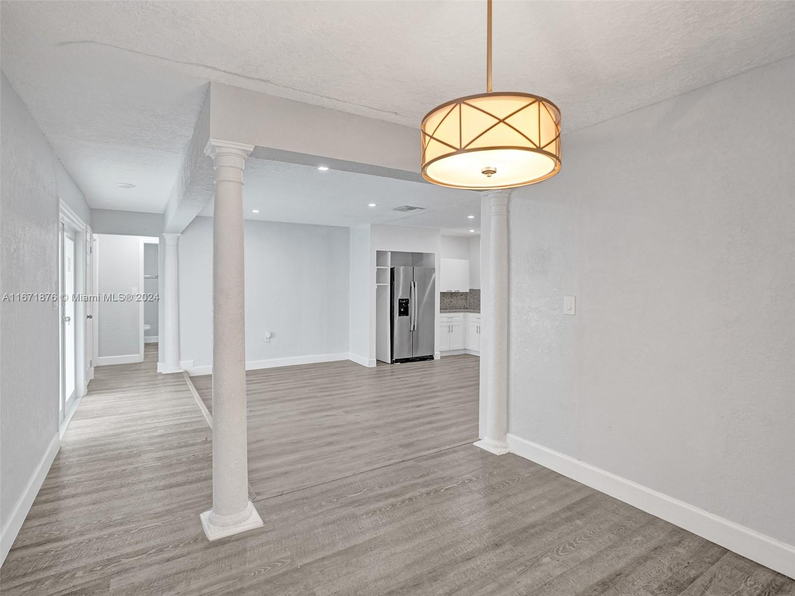 a view of a hallway with wooden floor and a chandelier