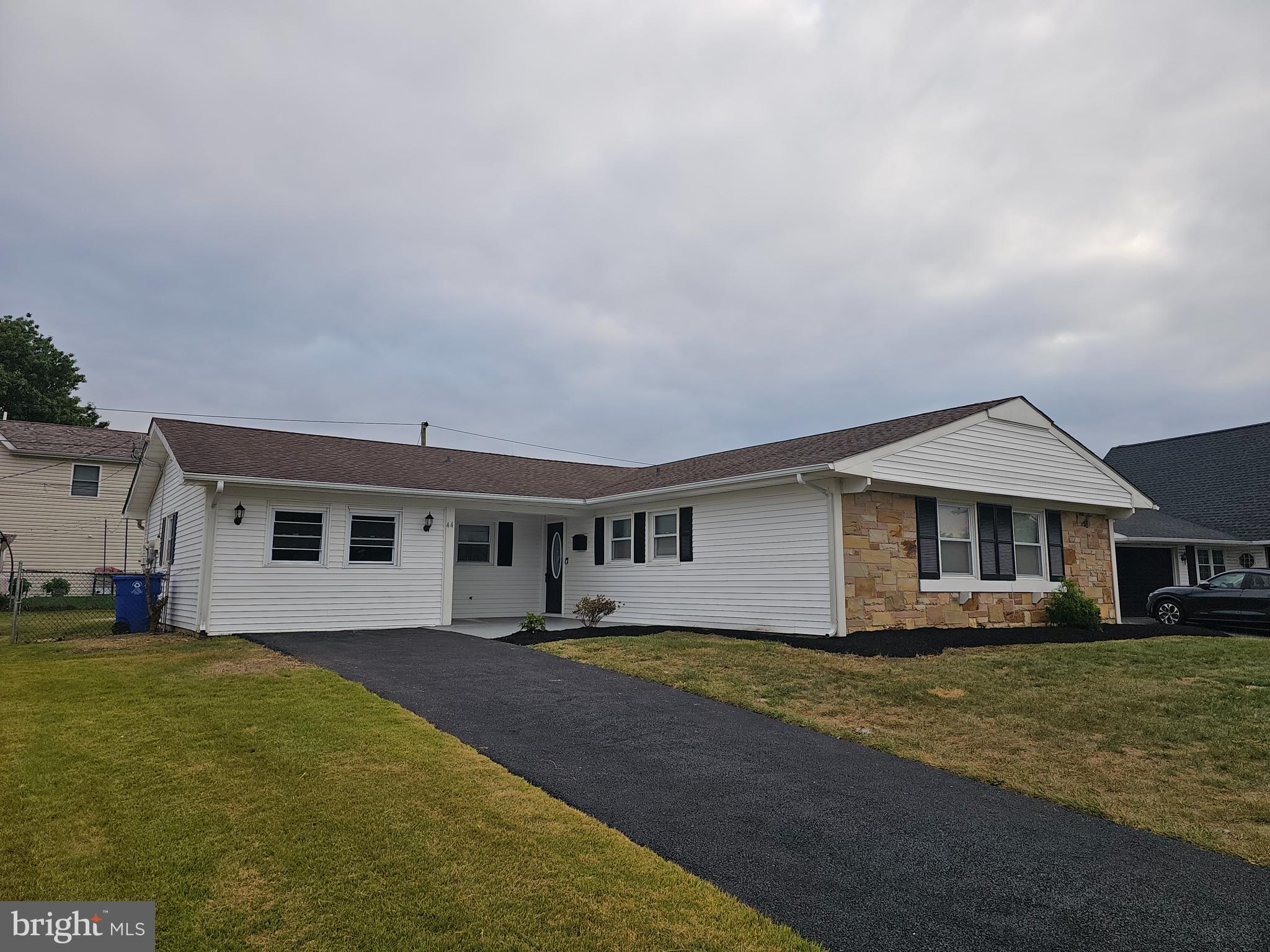 a front view of house with yard and trees in the background