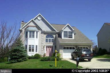 a front view of a house with a garden and plants