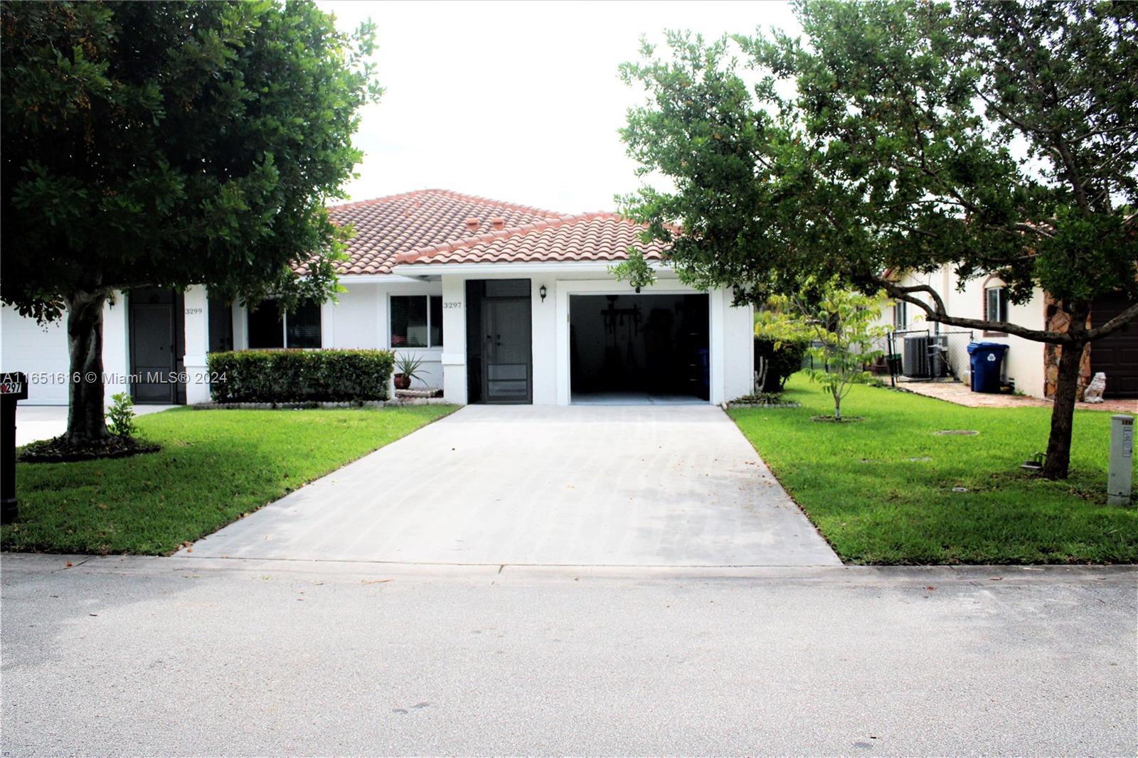 a front view of a house with yard and green space