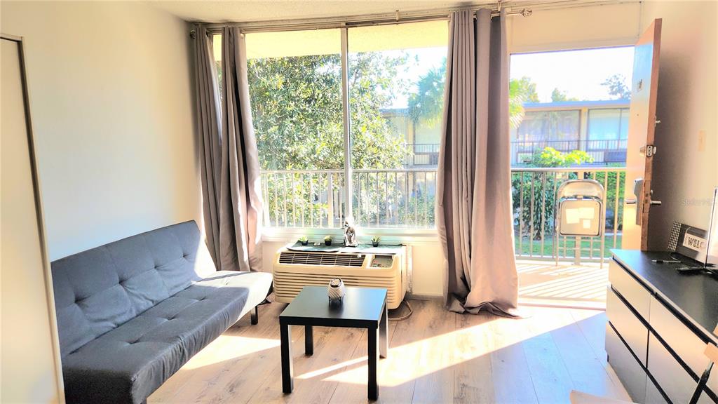 a living room with furniture and a floor to ceiling window