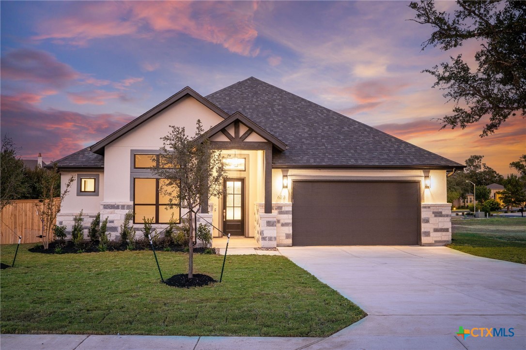 a front view of a house with a yard and garage