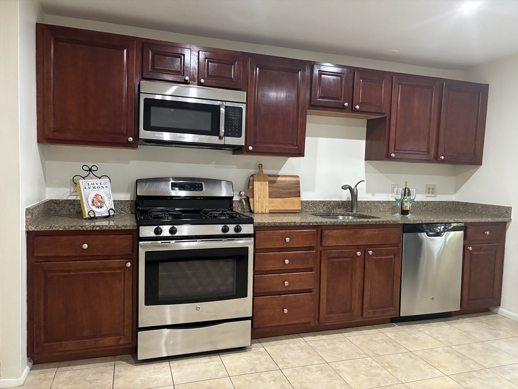 a kitchen with stainless steel appliances granite countertop a stove microwave and sink