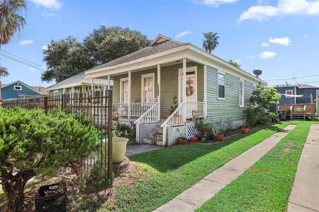 a front view of a house with a yard and potted plants