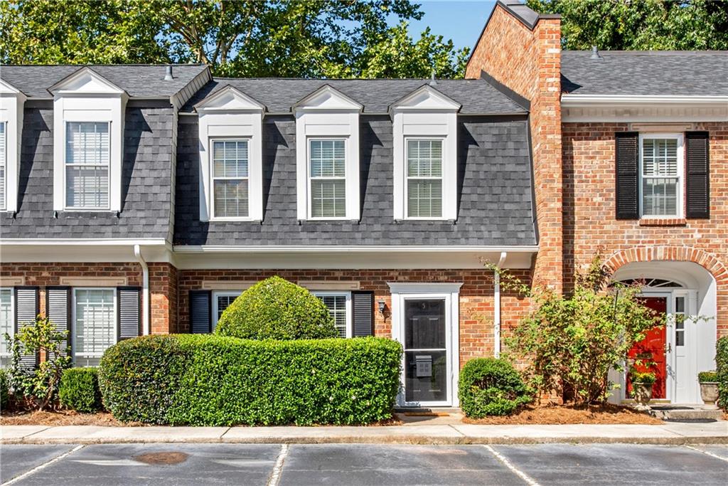 front view of a brick house with a yard