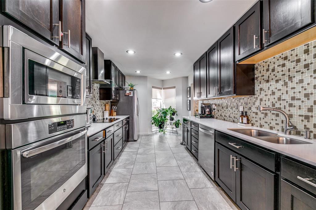 a large kitchen with stainless steel appliances cabinets a sink and a counter top space