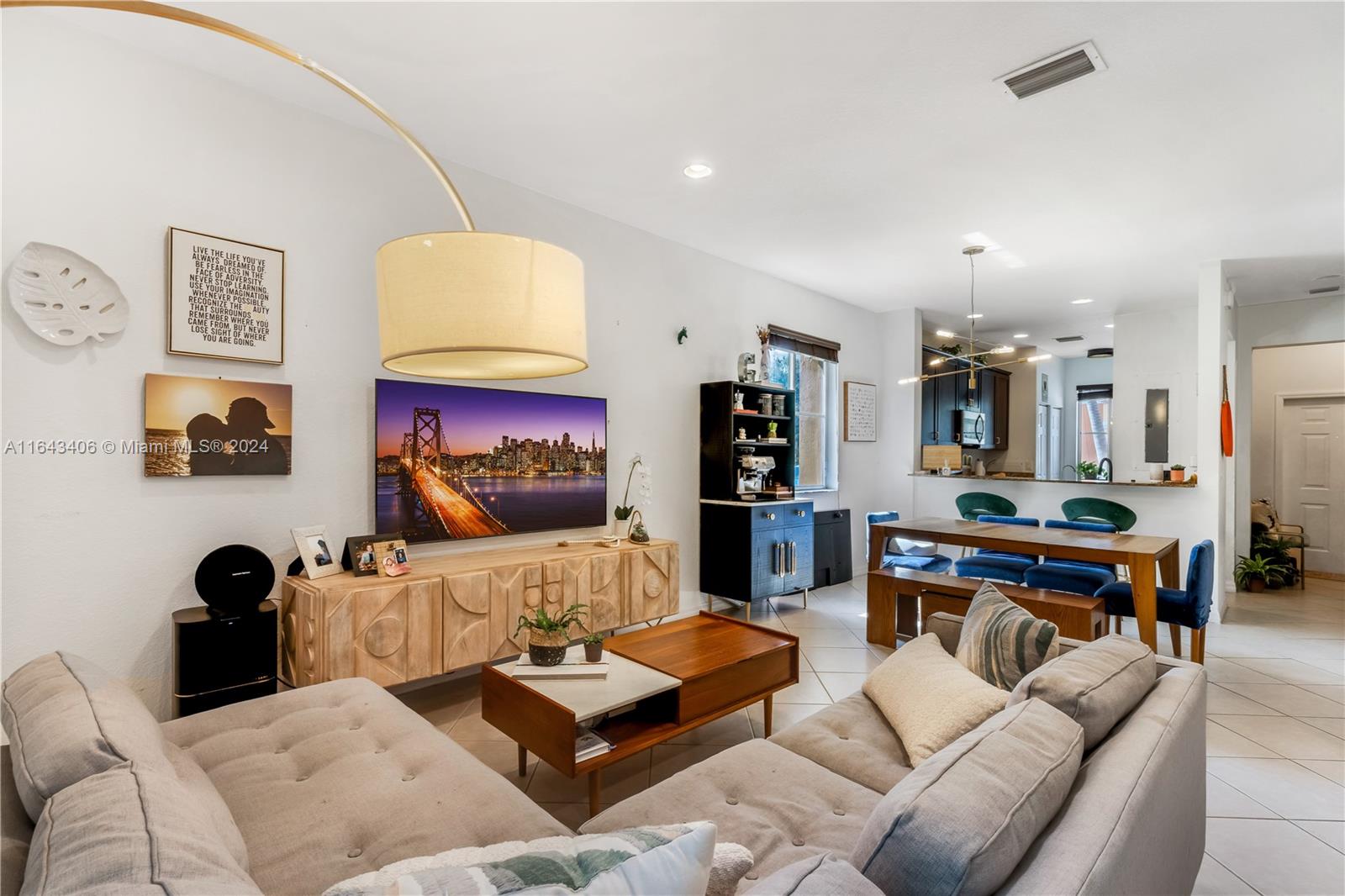 a living room with furniture kitchen view and a window