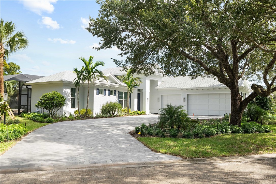 a front view of a house with garden and trees