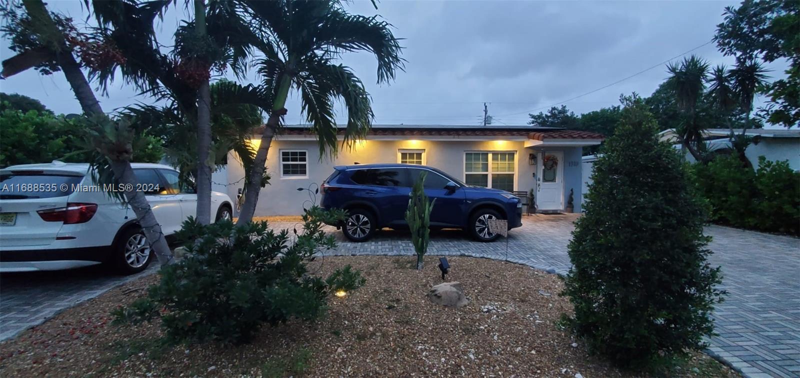 a view of a yard with cars parked on the road