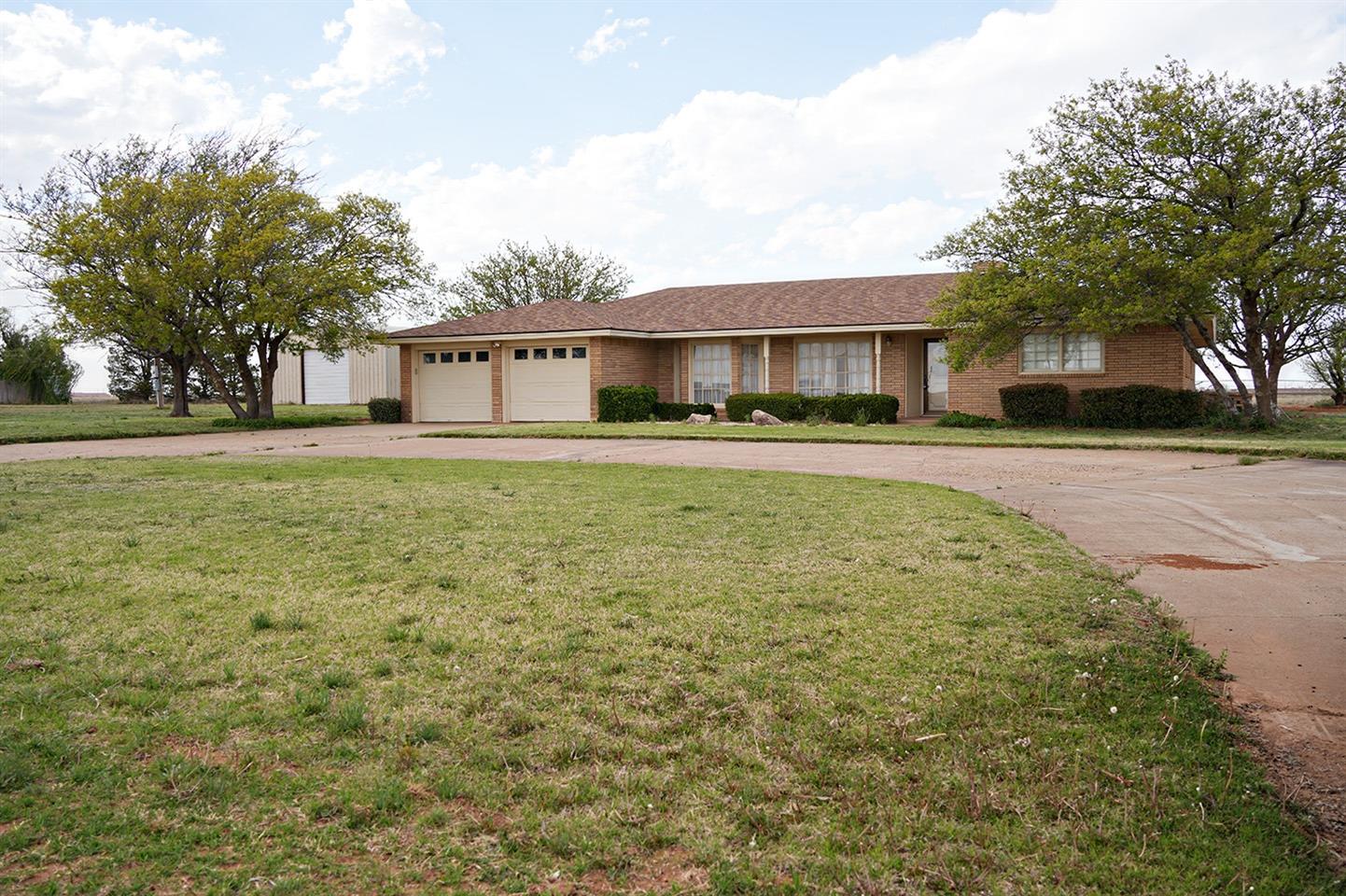 a front view of a house with a garden and trees