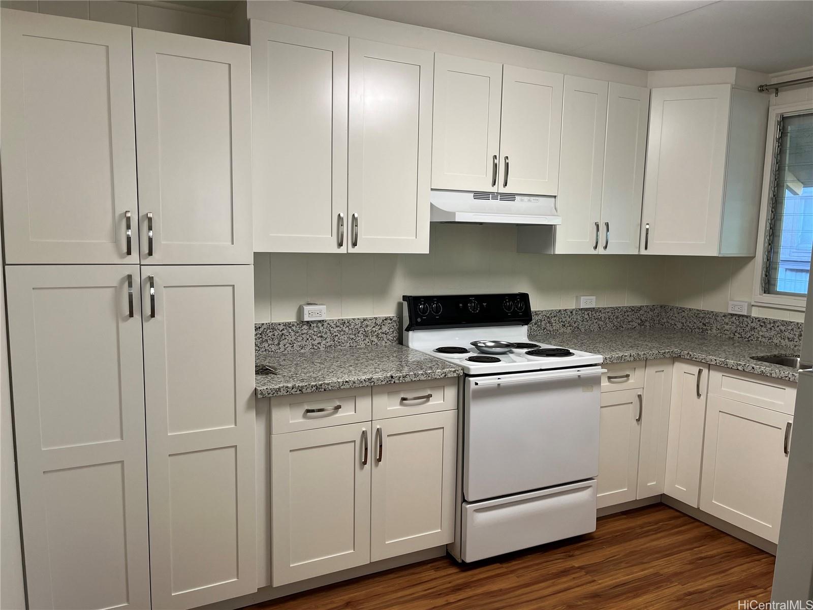 a kitchen with granite countertop white cabinets and white appliances