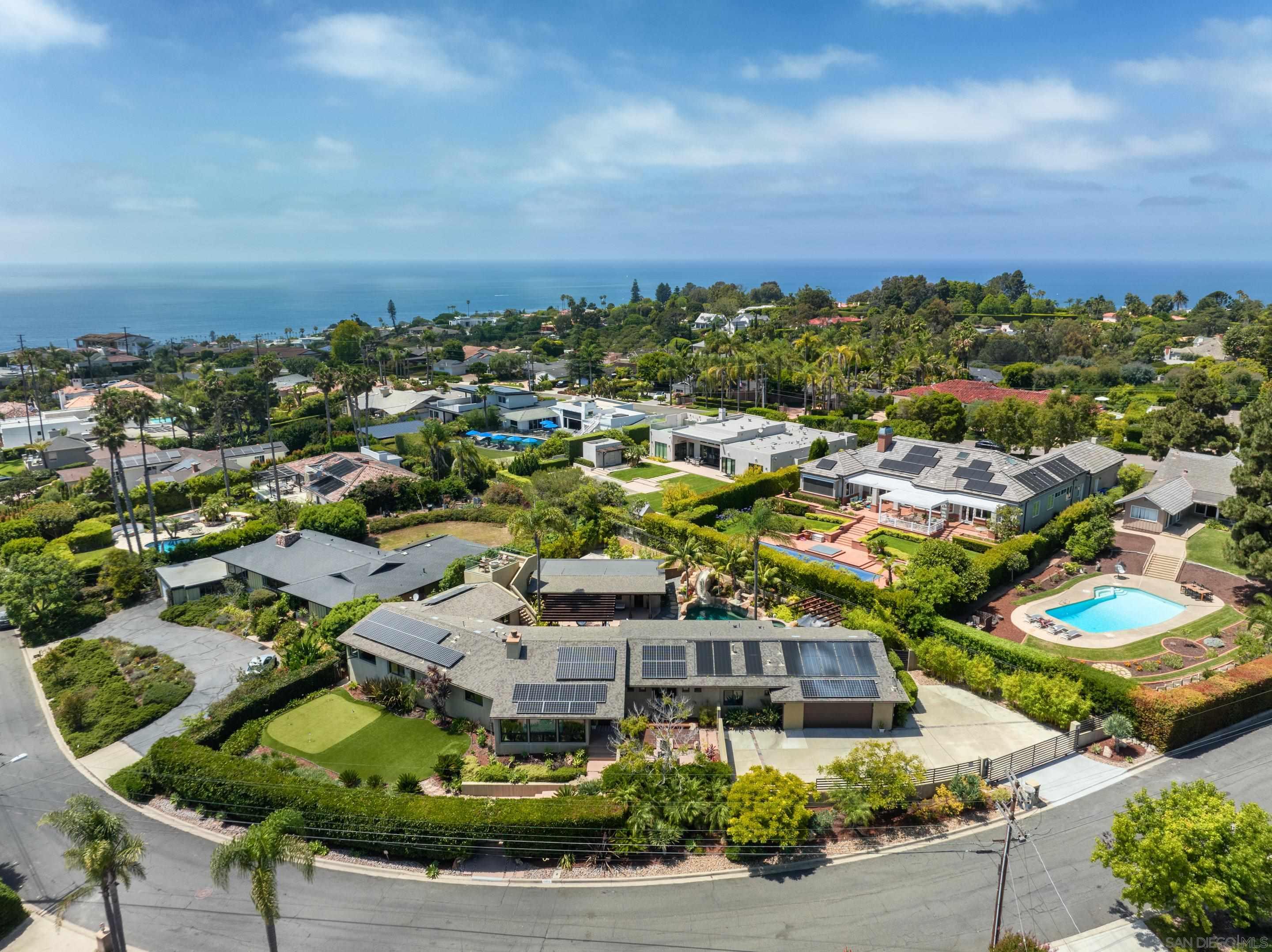 an aerial view of residential houses with outdoor space and street view