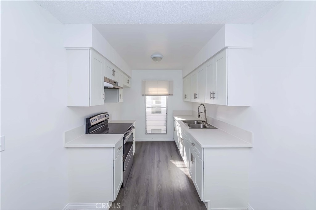 a kitchen with a stove a sink and a refrigerator