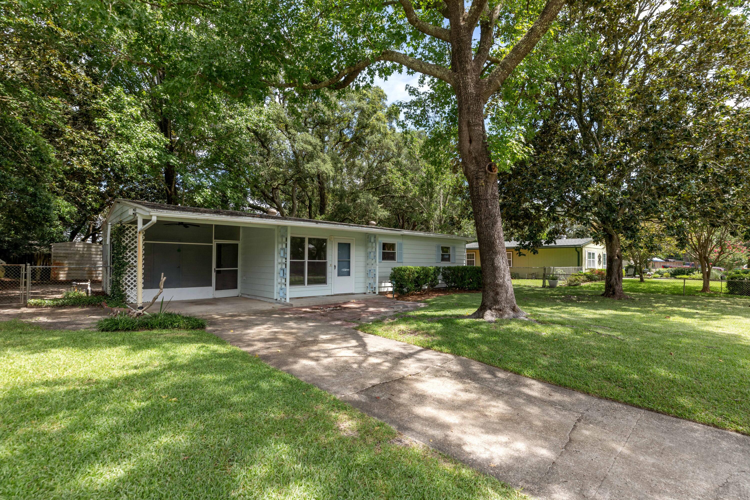 a view of a yard with a house and a large tree