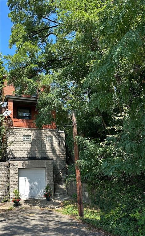 Imagine a charming one to two-bedroom home perched on Mount Washington, on a quiet treed street. This updated and well-built residence is a perfect blend of modern amenities and classic appeal. The exterior showcases a timeless design, with sturdy construction that speaks to the quality of the build. The house has a timeless, classic look with its rich red brick façade, complemented by white trim around the doors.