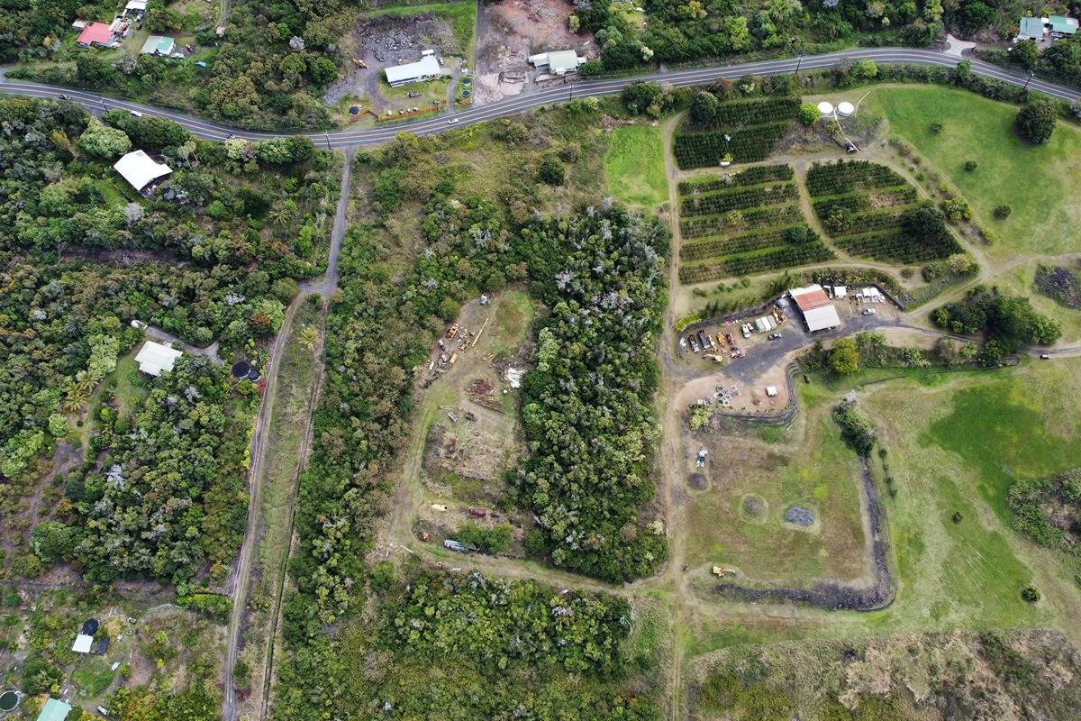 an aerial view of residential houses with outdoor space and trees