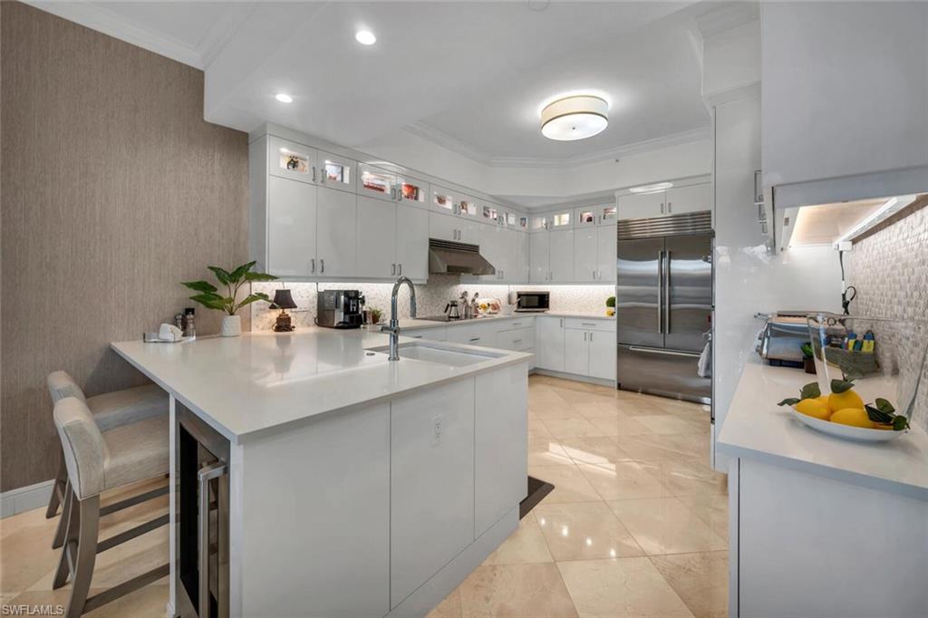 a kitchen with refrigerator and chairs