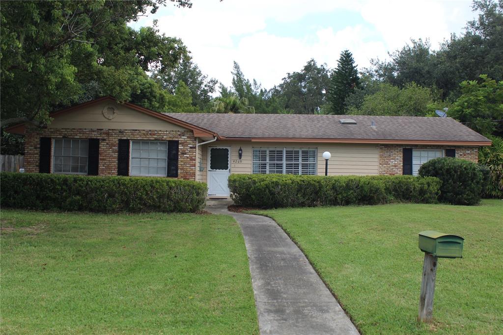 a front view of a house with a yard and trees