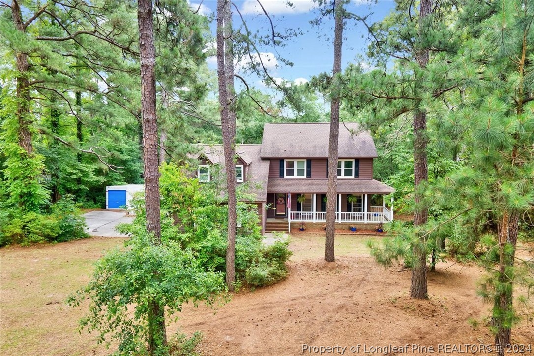 an aerial view of a house with a yard and large trees