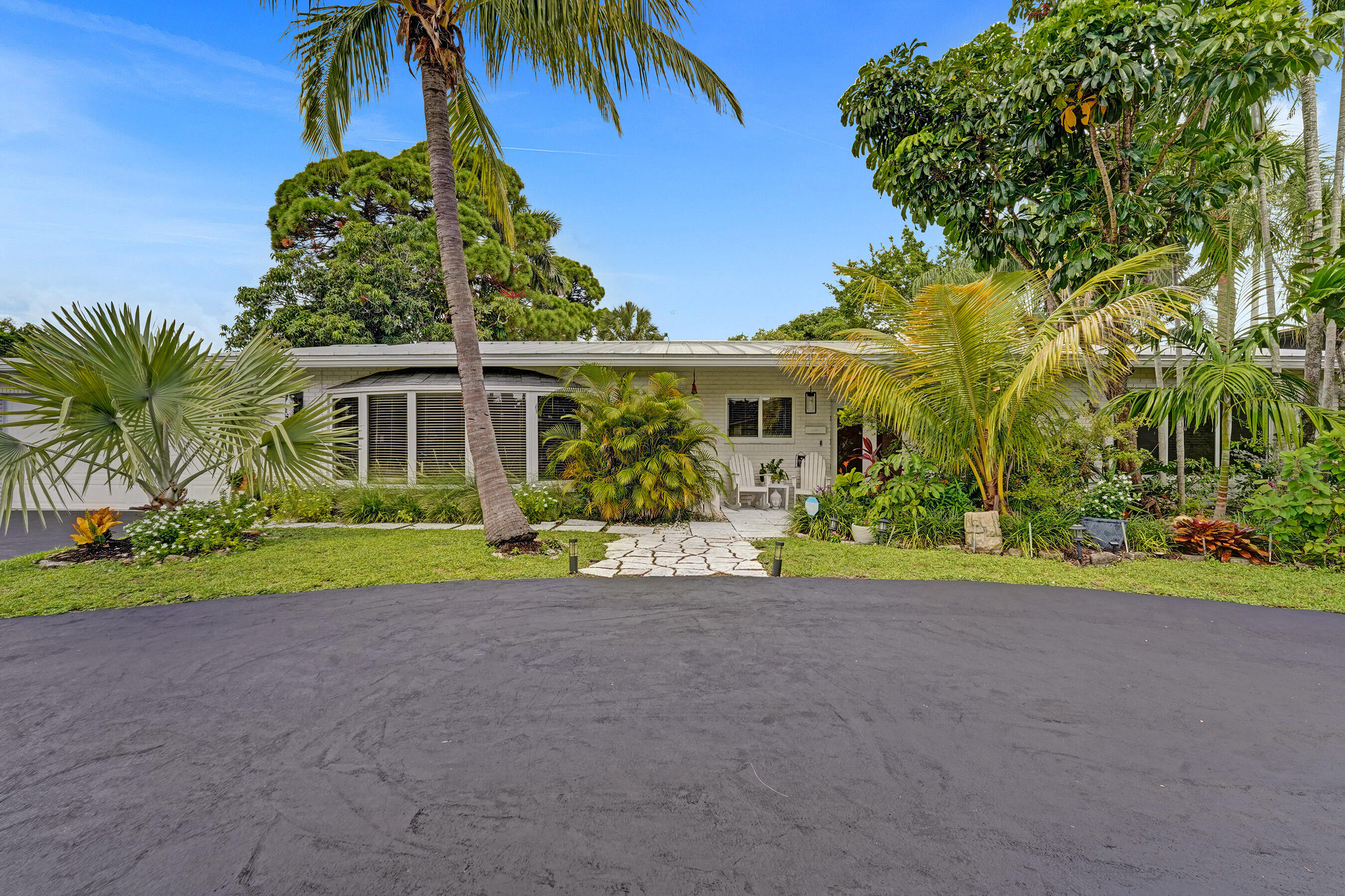 a front view of a house with a yard and potted plants