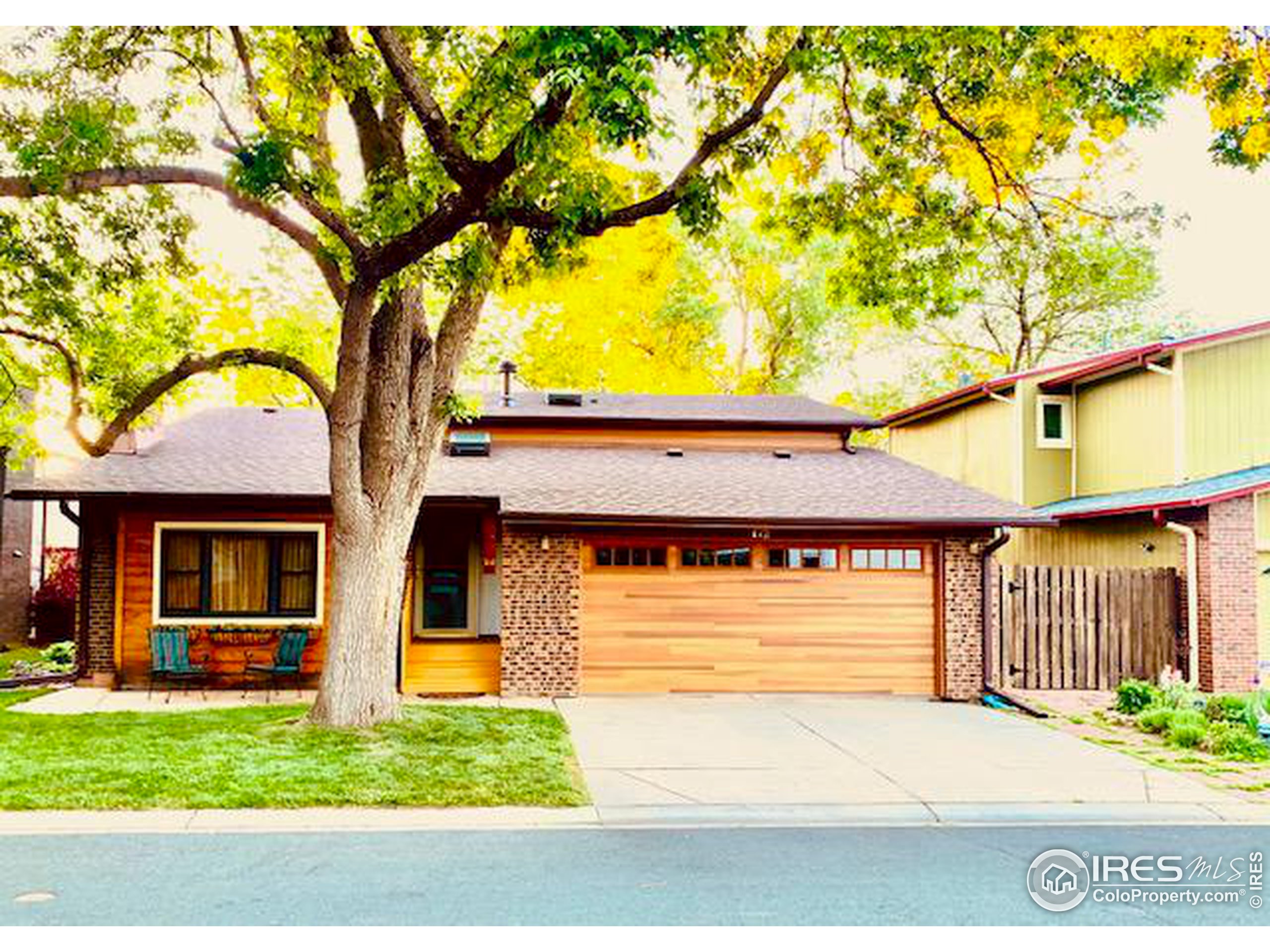 a front view of a house with a garden and trees