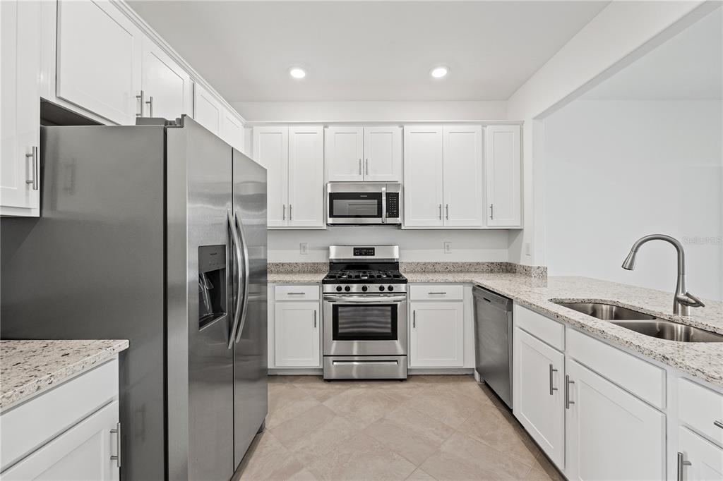 a kitchen with cabinets stainless steel appliances and a sink