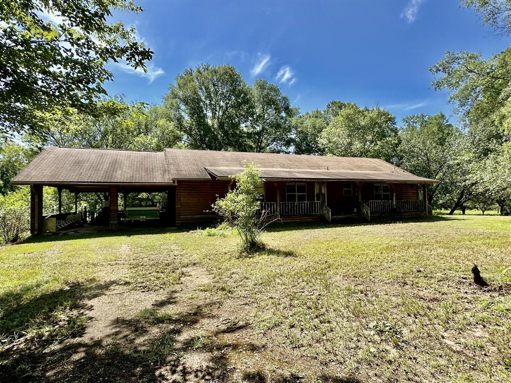 a view of house with yard and outdoor seating