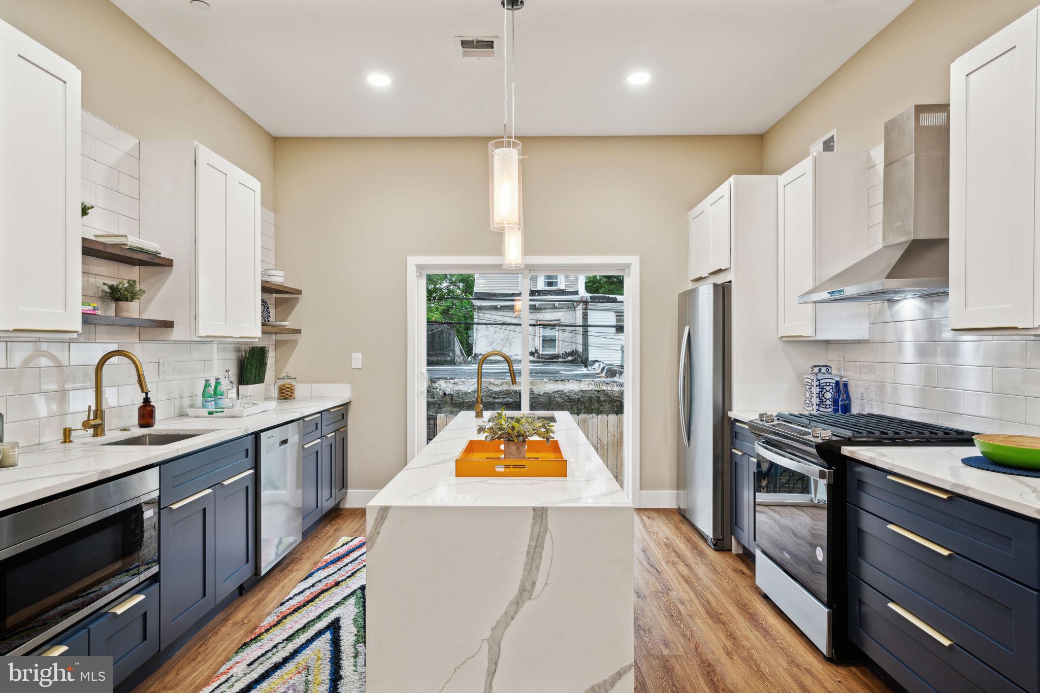 a kitchen with stainless steel appliances granite countertop a sink a stove and a refrigerator