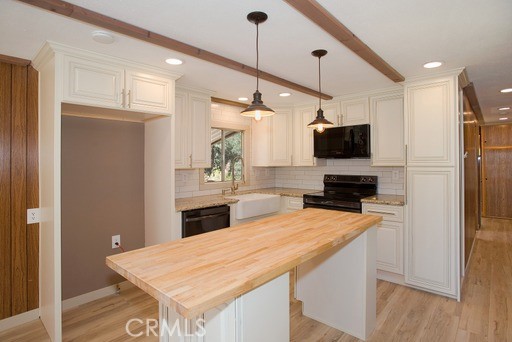 a kitchen with a refrigerator a sink and a microwave