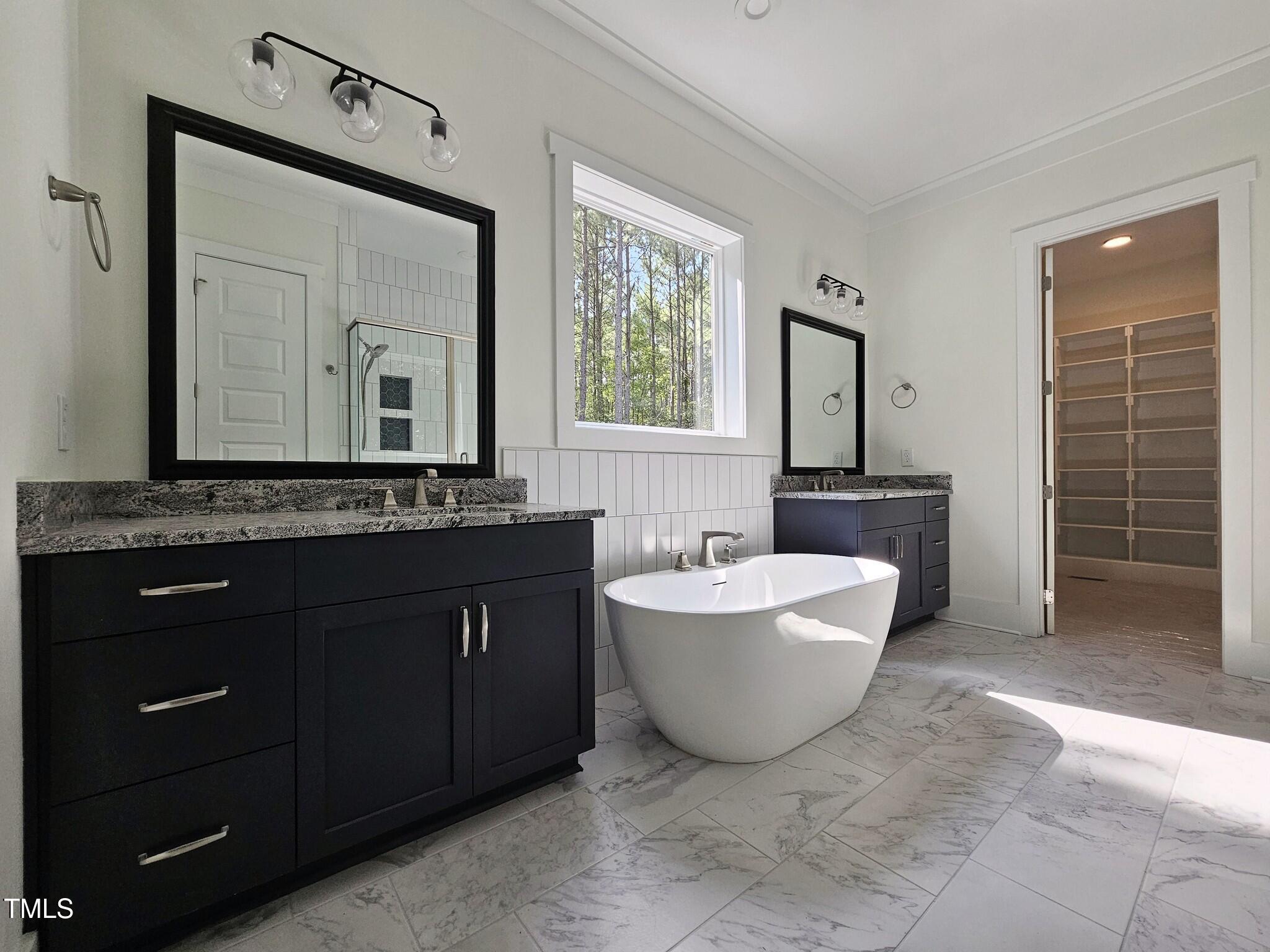 a spacious bathroom with a bathtub sink and mirror