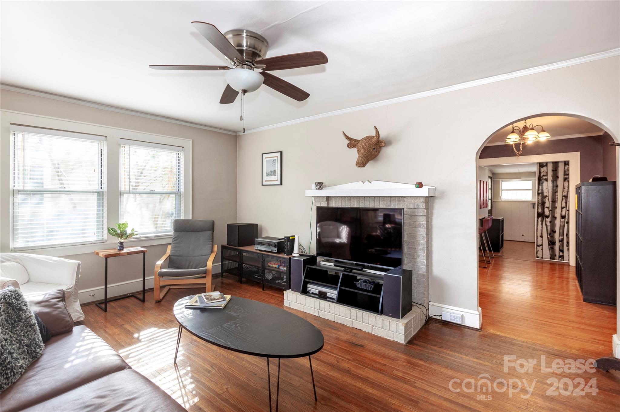 a living room with furniture a fireplace and a large window