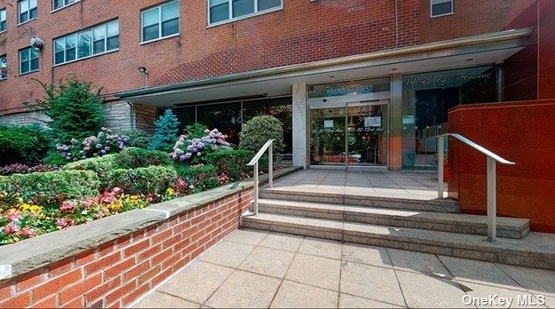 a front view of a house with entryway and flowers