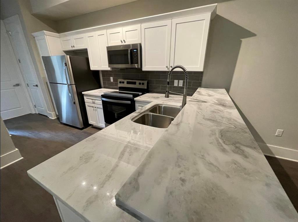 a kitchen with stainless steel appliances a refrigerator sink and microwave