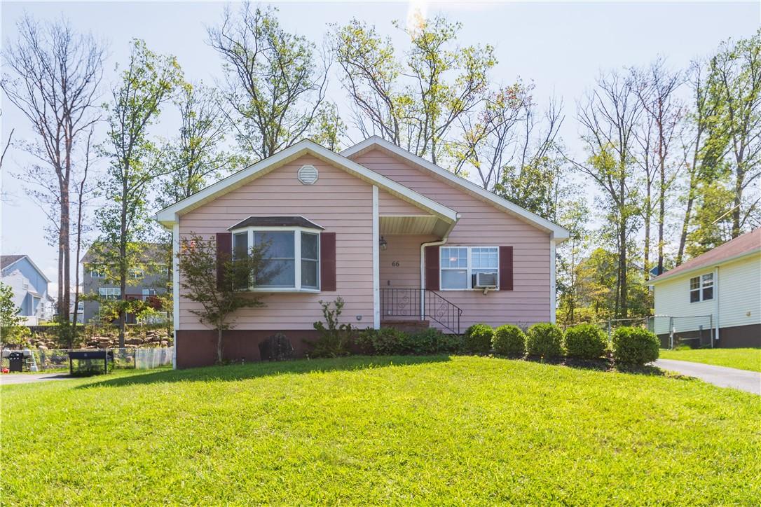 a front view of a house with a yard and trees