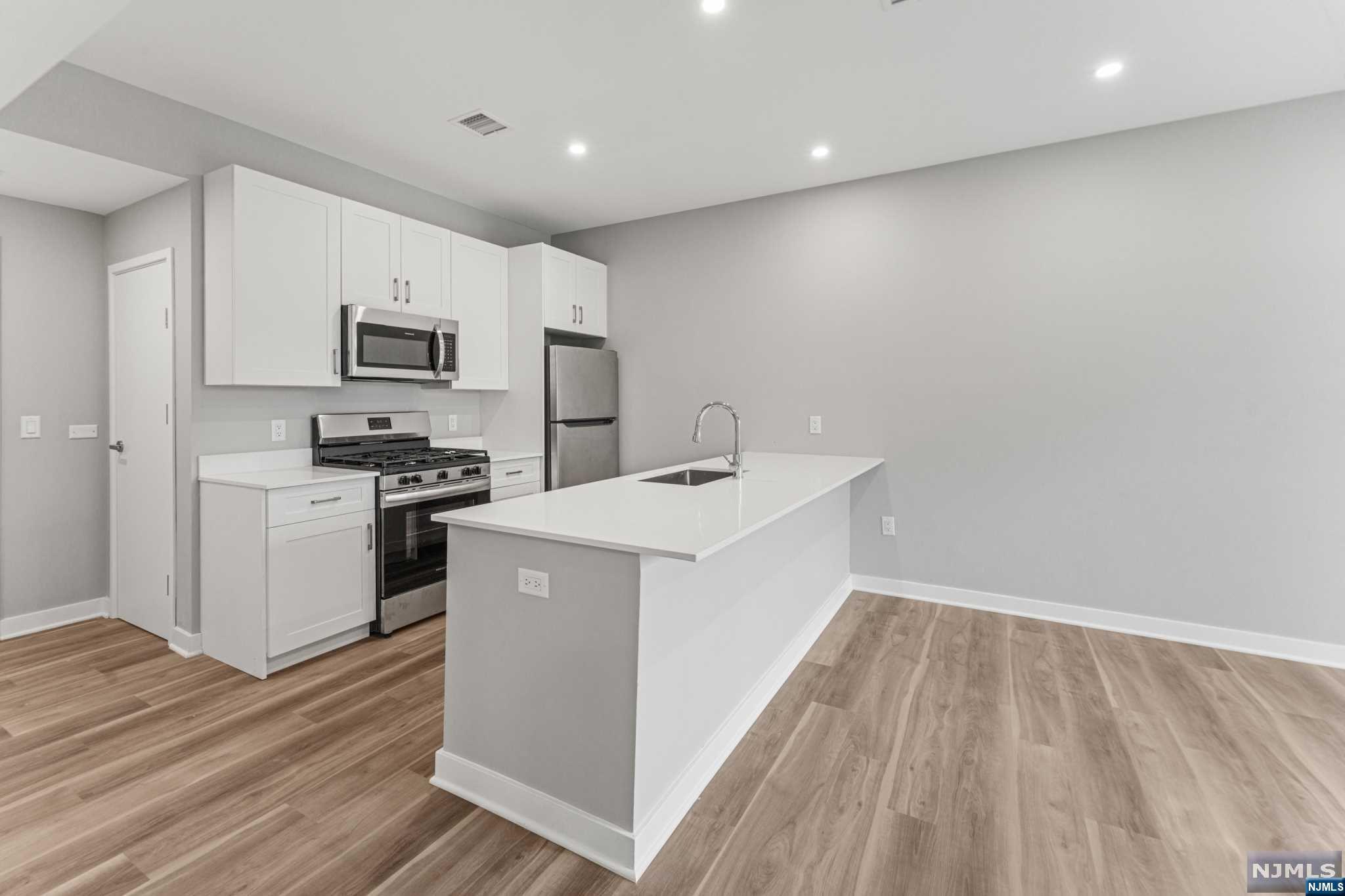 a kitchen with stove cabinets and refrigerator