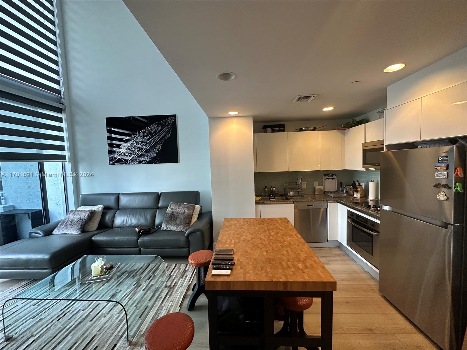 a living room with furniture and a kitchen view