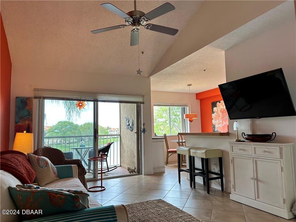 a living room with furniture a flat screen tv and floor to ceiling window