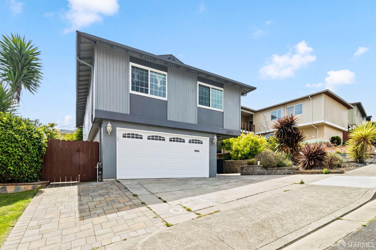 a front view of a house with a yard and a garage