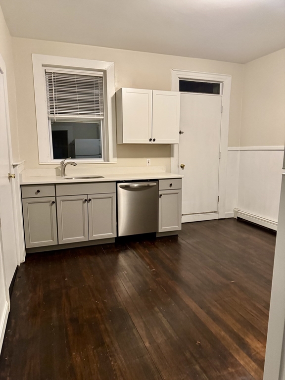 a view of a kitchen counter space a sink wooden floor and a window