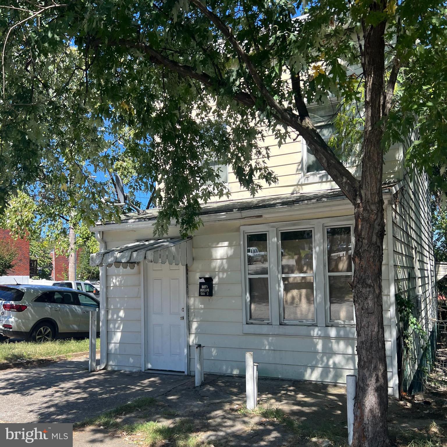 a front view of a house with a tree