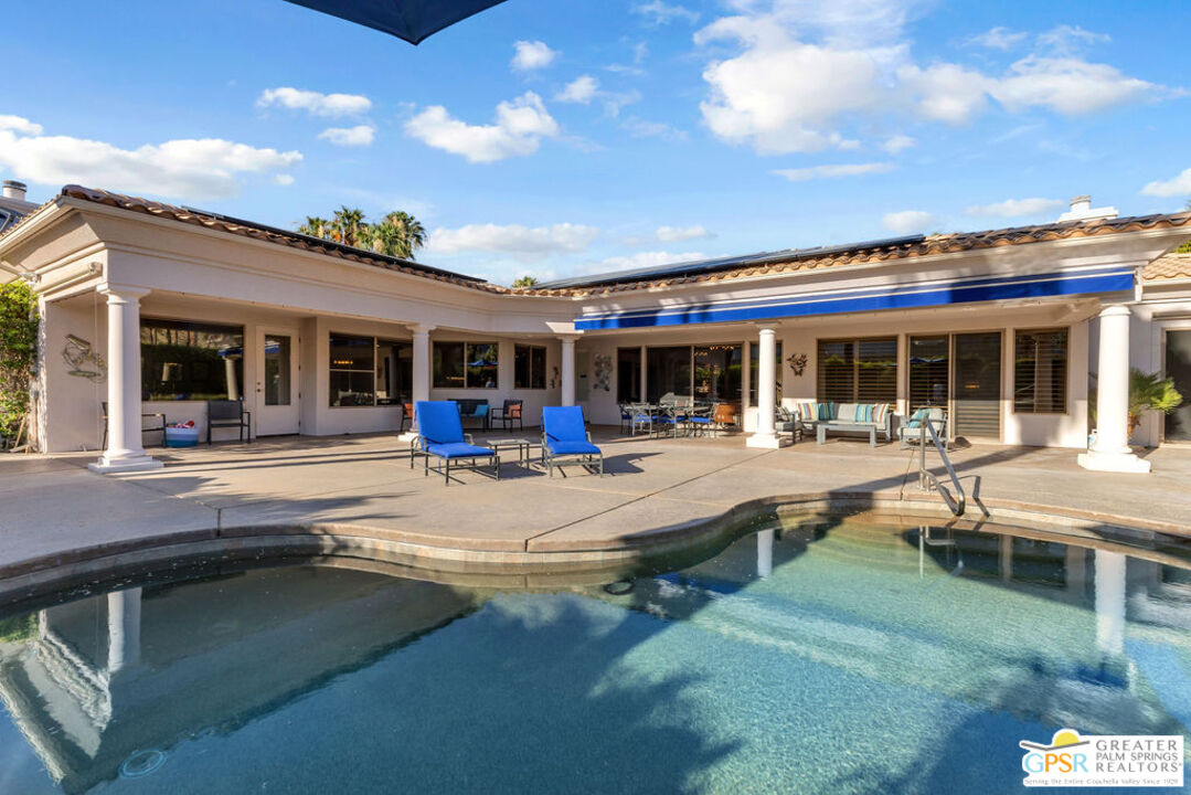 a view of a patio with dining table and chairs with a barbeque grill and a small yard