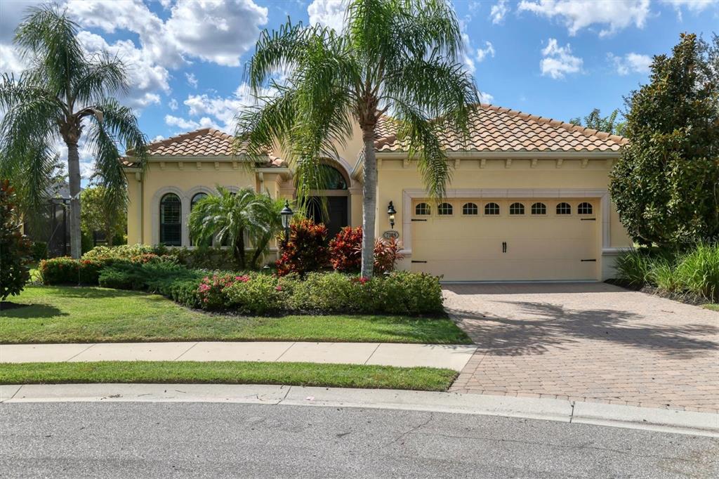 a view of a house with a yard and palm trees