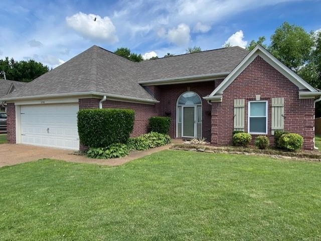 Ranch-style house with a front yard and a garage