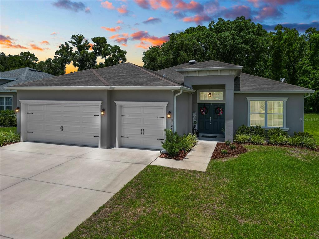 a front view of a house with a yard and a garage