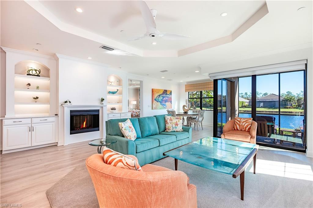 a living room with fireplace furniture and a large window