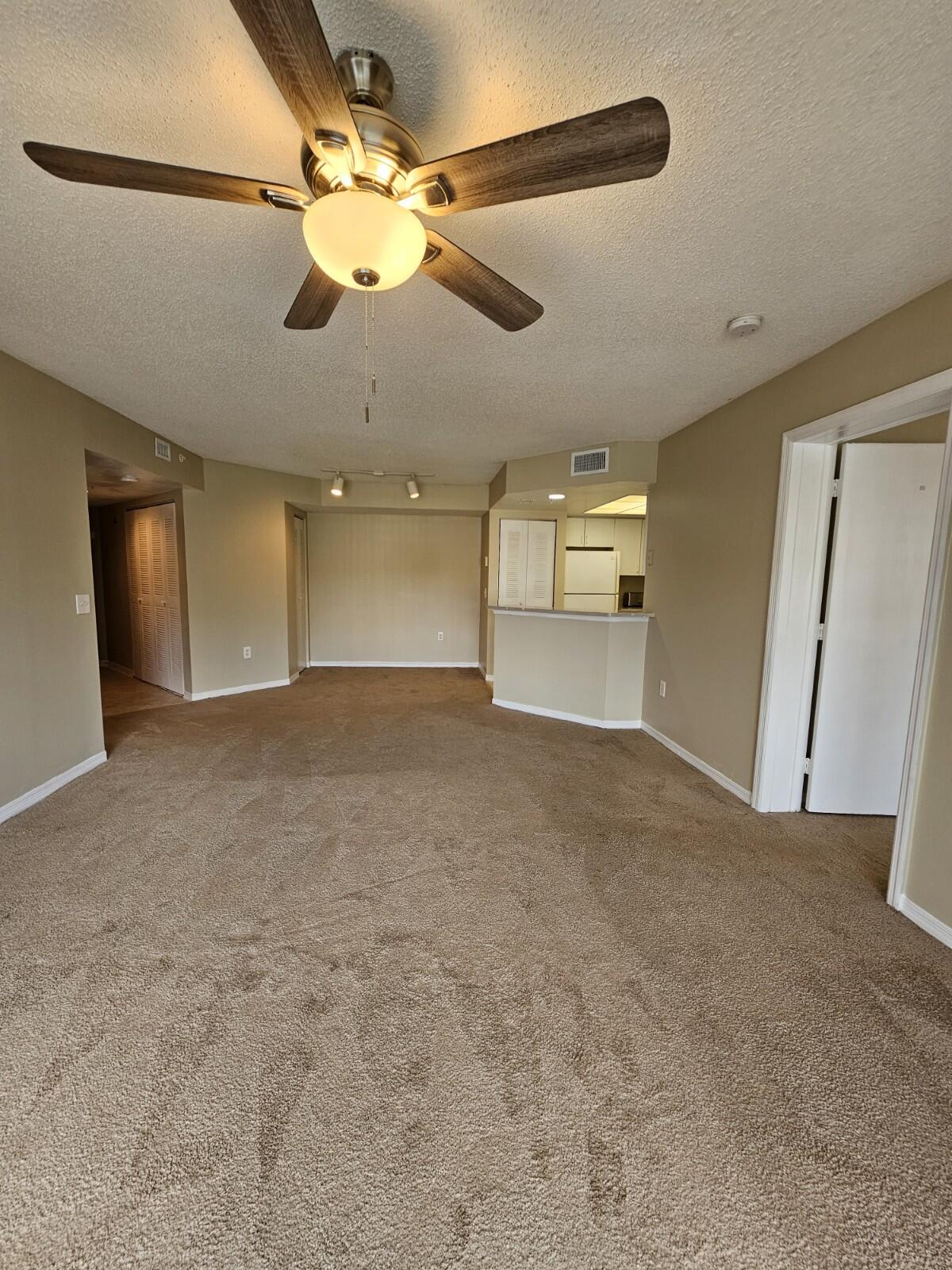 a view of a livingroom with a ceiling fan and window